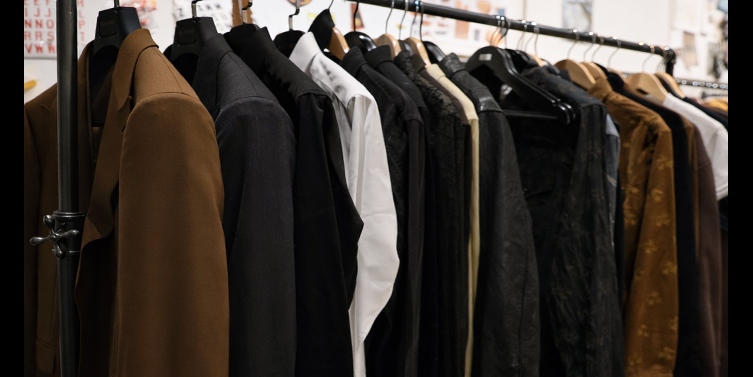Clothing rack with various jackets and coats hanging on it.