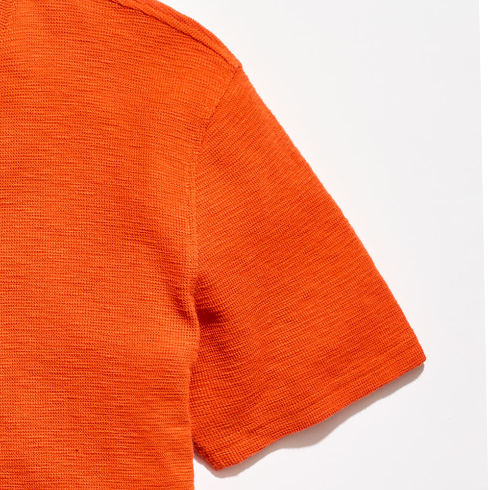 Close-up of an orange textured fabric on a white background
