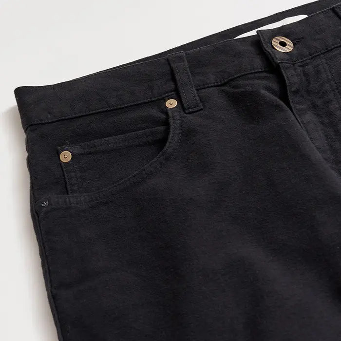 Close-up of black pants with button details on a white background