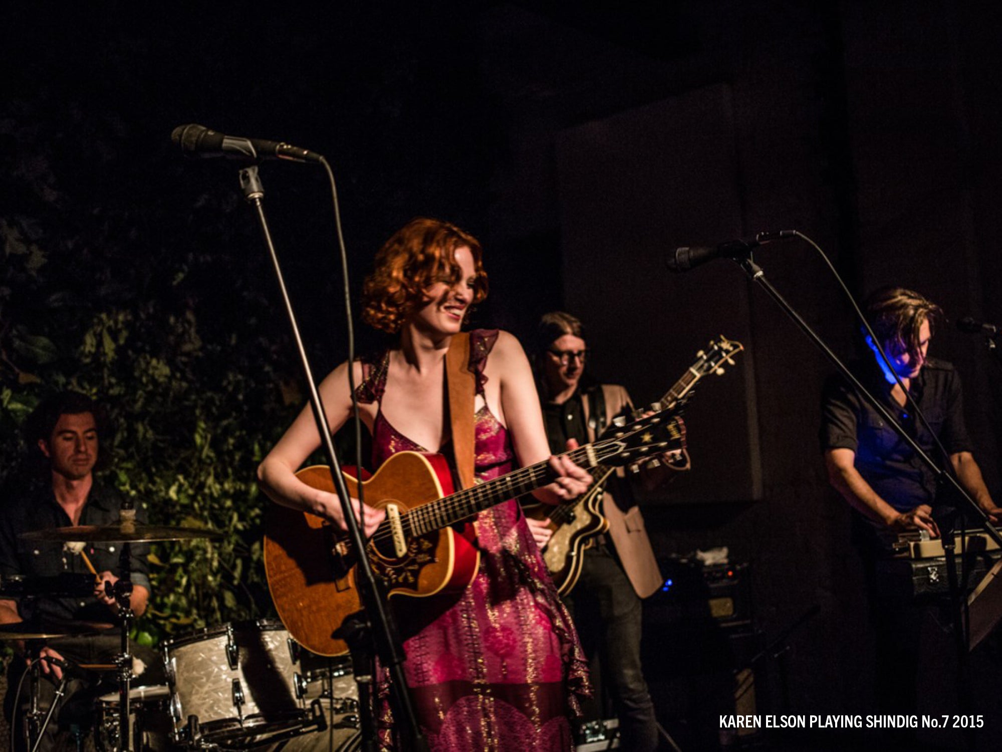 Woman sings and plays guitar at Shindig.