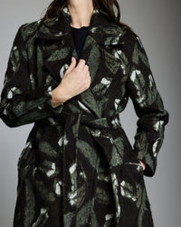 Black coat with abstract pattern worn by a person on a gray background