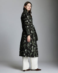 Woman wearing a black patterned coat against a gray background