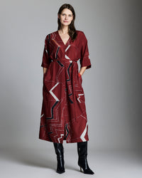 Female model shows the fit of the dress Mountain Silk V Pleat Maxi Dress in Maroon