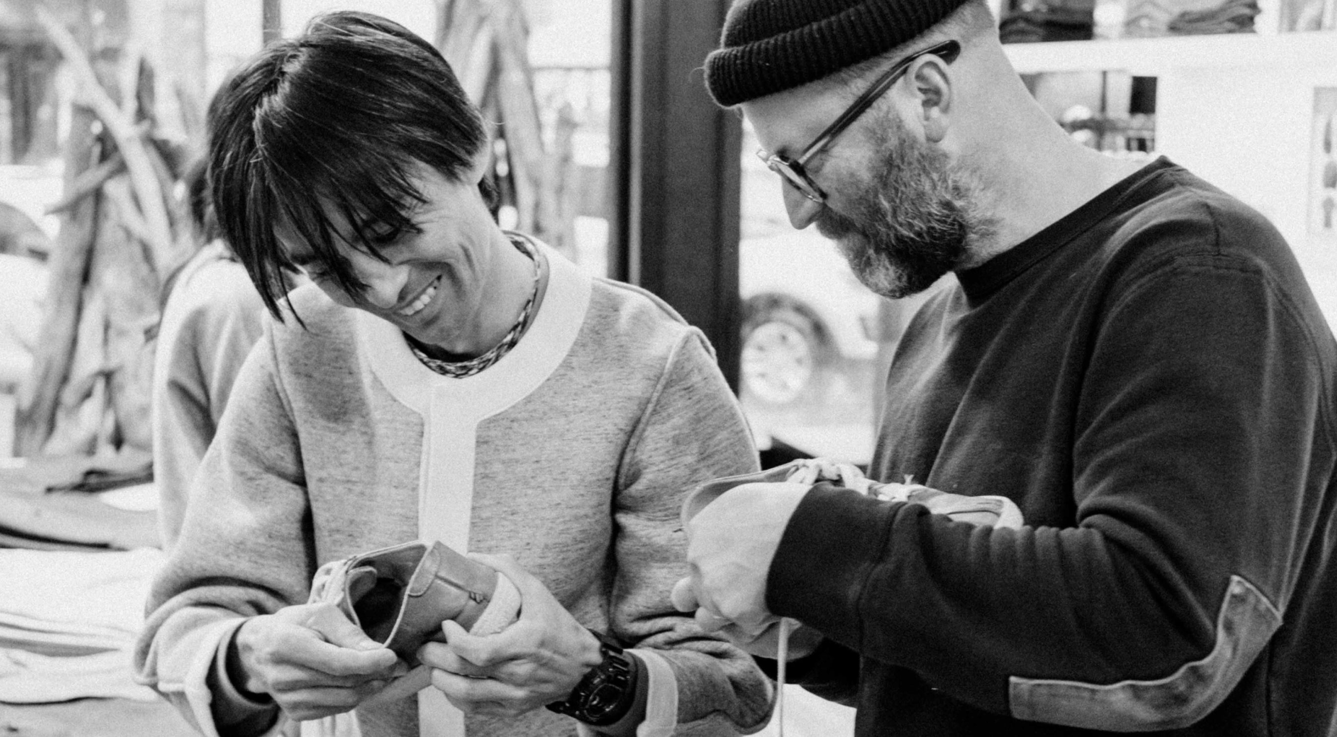 Two people examining a small object together in an indoor setting.