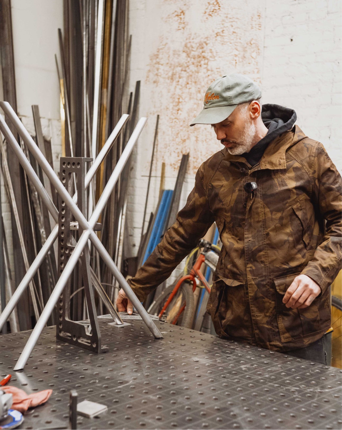 Man in a workshop examining metal frames
