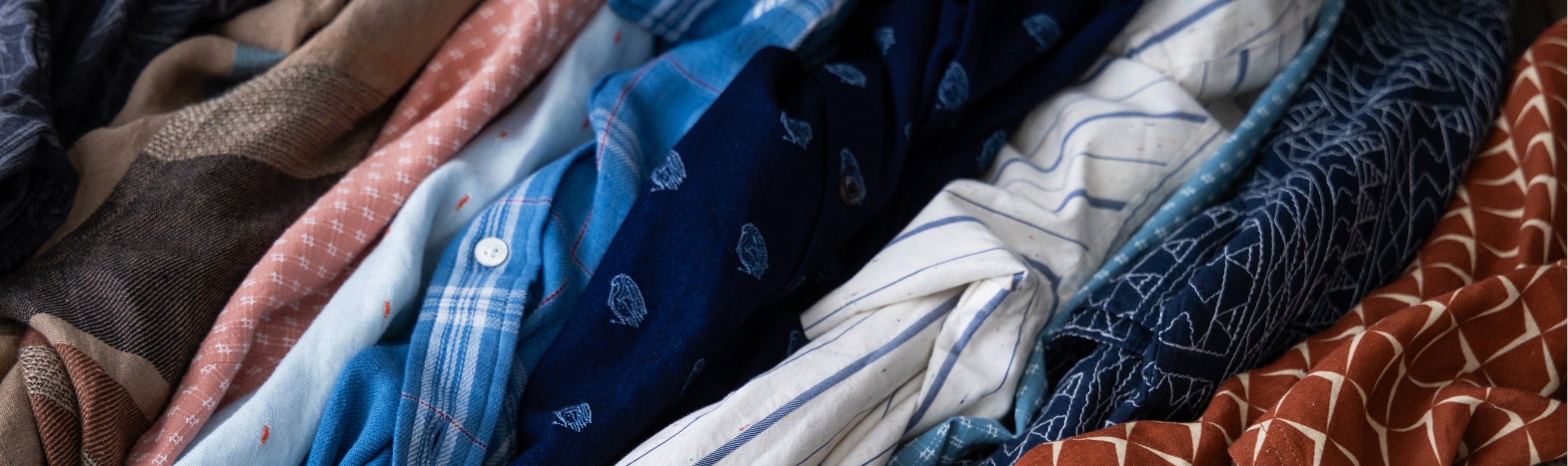 Stack of folded clothes in various colors and patterns