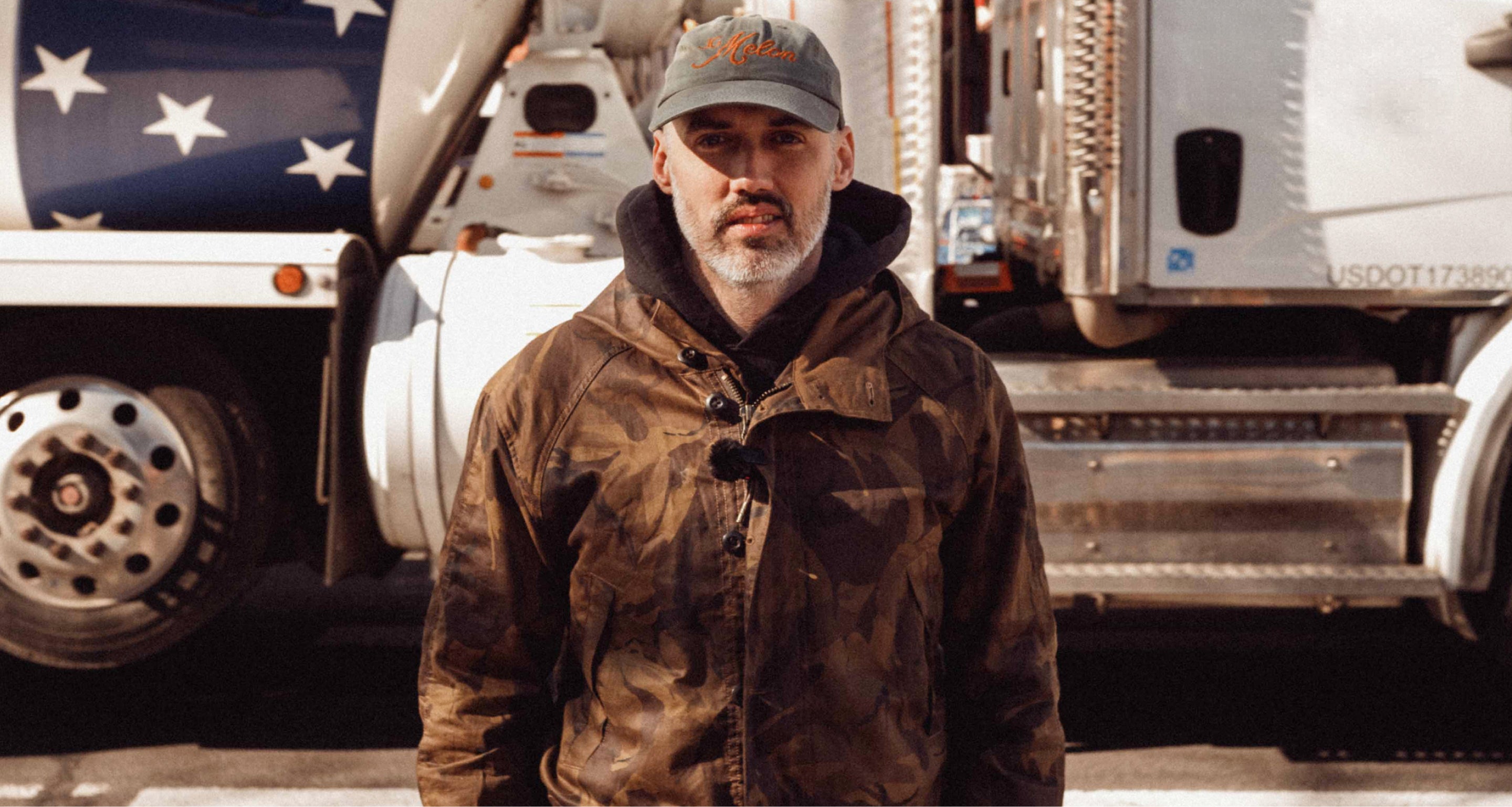 Man standing in front of a large truck with an American flag design.