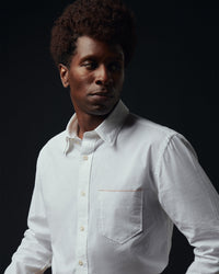 Man wearing a white shirt against a black background