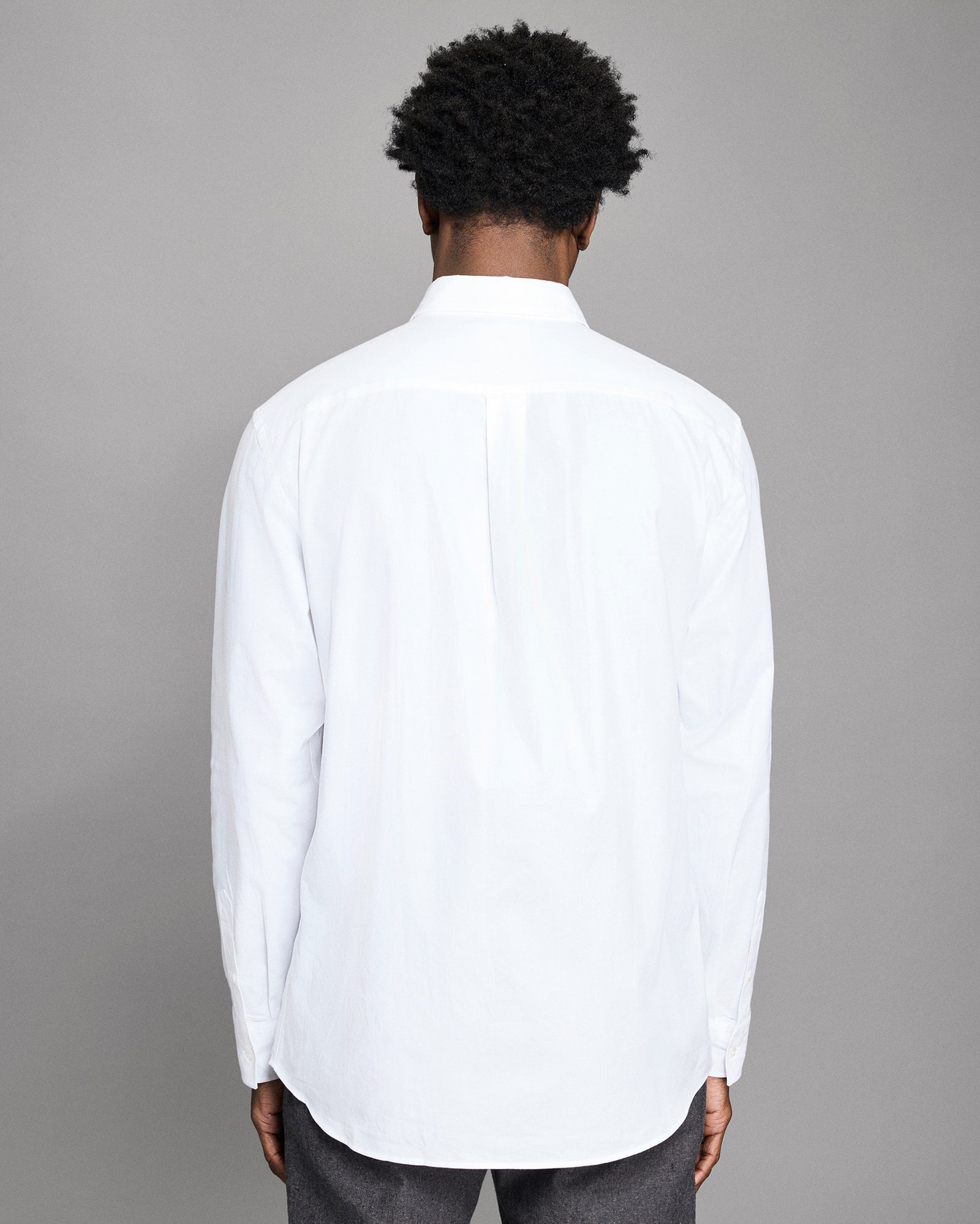 Person wearing a white shirt with a gray background