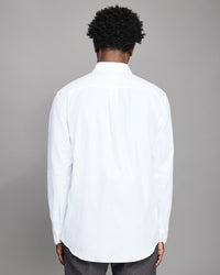 Person wearing a white shirt with a gray background