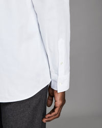 White shirt with rolled-up sleeves and a gray background
