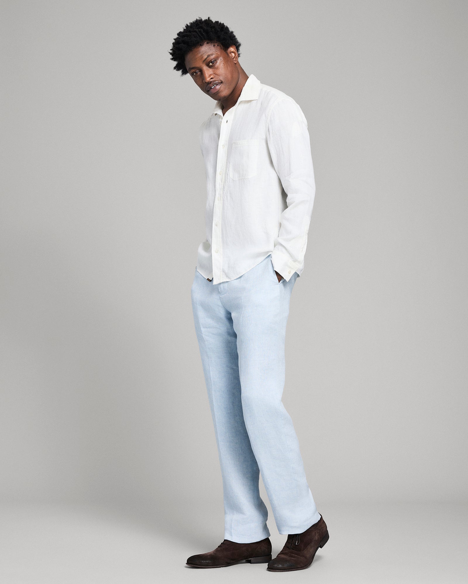 Person wearing a white shirt and light blue jeans on a gray background