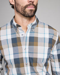 Man wearing a plaid shirt with a neutral background