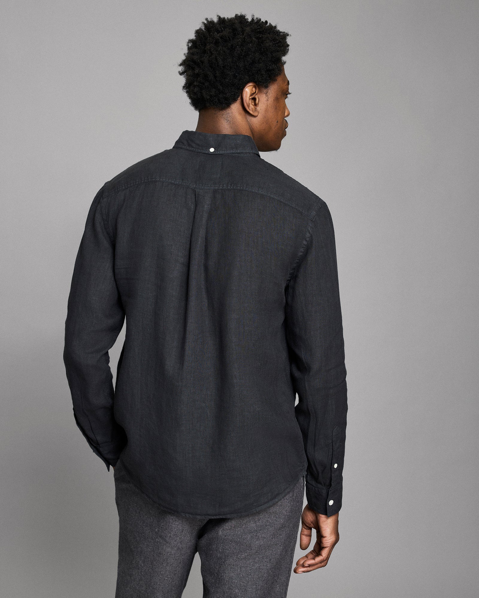 Man wearing a black shirt against a gray background