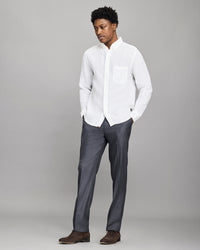 Man wearing a white shirt and gray pants against a gray background