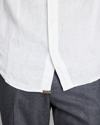 Close-up of a white shirt with a collar and gray pants on a light gray background