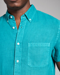 Teal button-up shirt worn by a person on a gray background