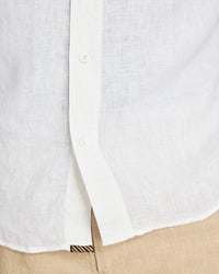 Close-up of a white button-up shirt with a beige pocket and pants.