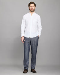Man wearing a white shirt and gray pants on a gray background