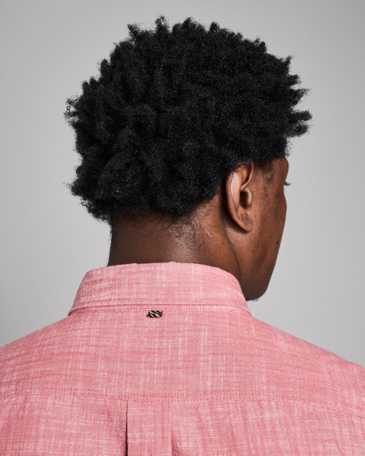 Person wearing a red checkered shirt with a gray background