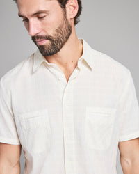 Man wearing a light-colored shirt against a plain background