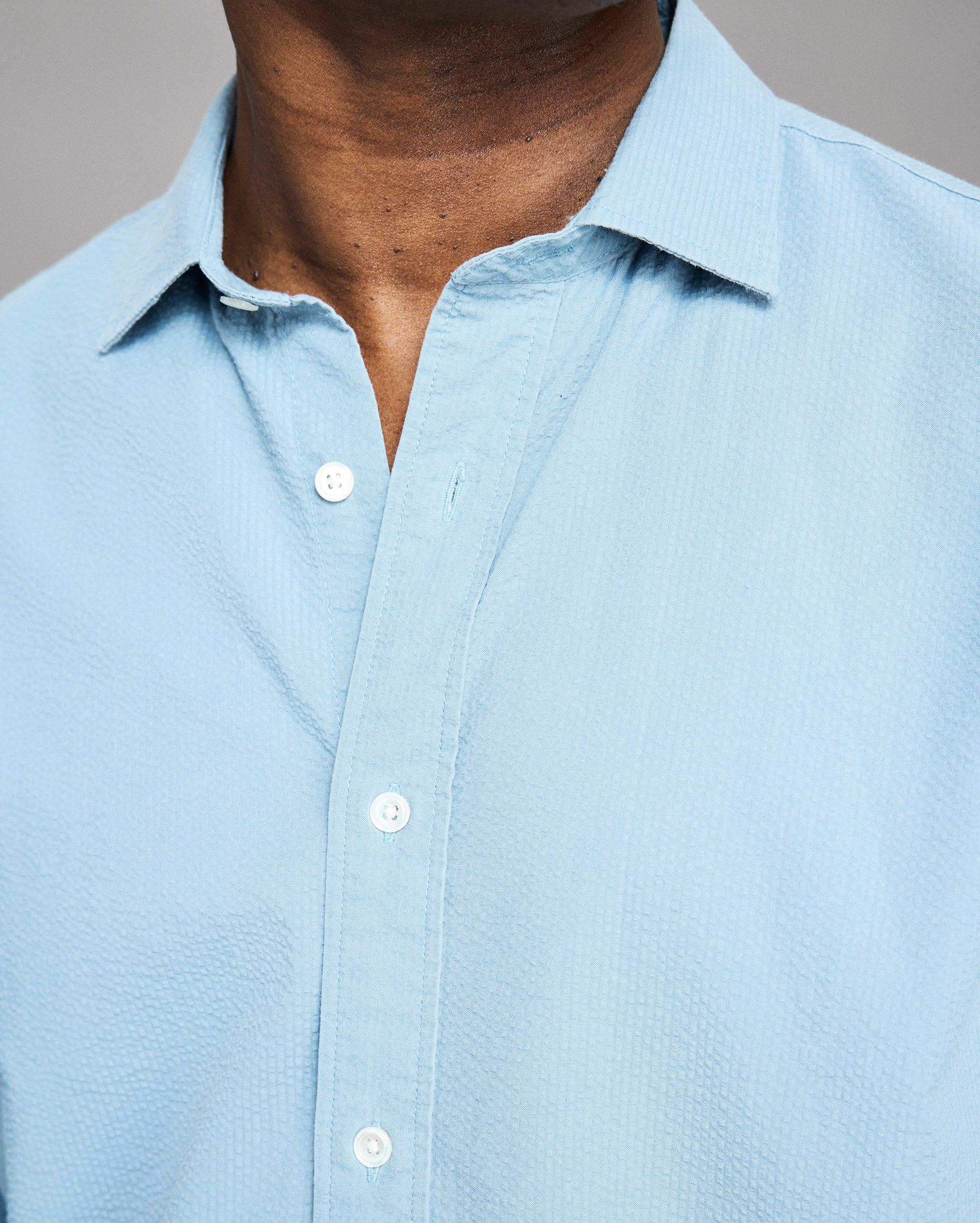 Light blue button-up shirt worn by a person, with a neutral background