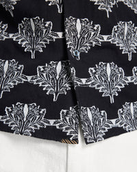 Close-up of black fabric with white leaf pattern on a white background