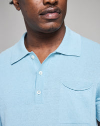 Man wearing a light blue polo shirt against a neutral background