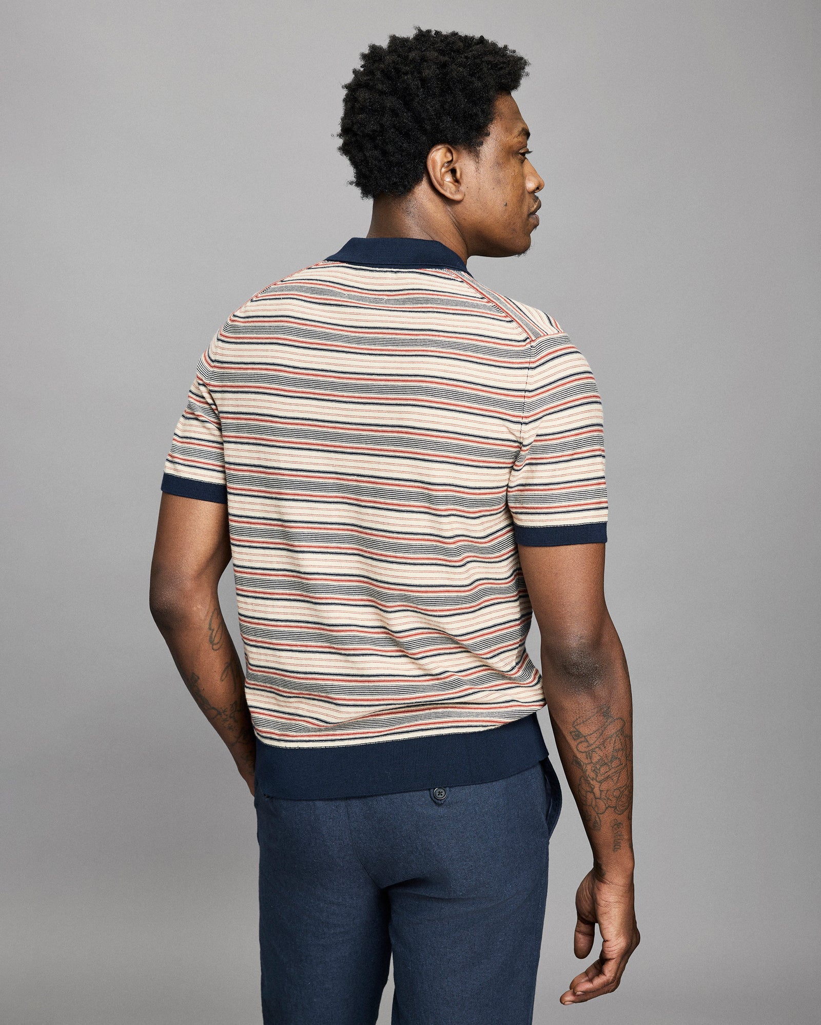 Model wears a striped polo on a light gray background