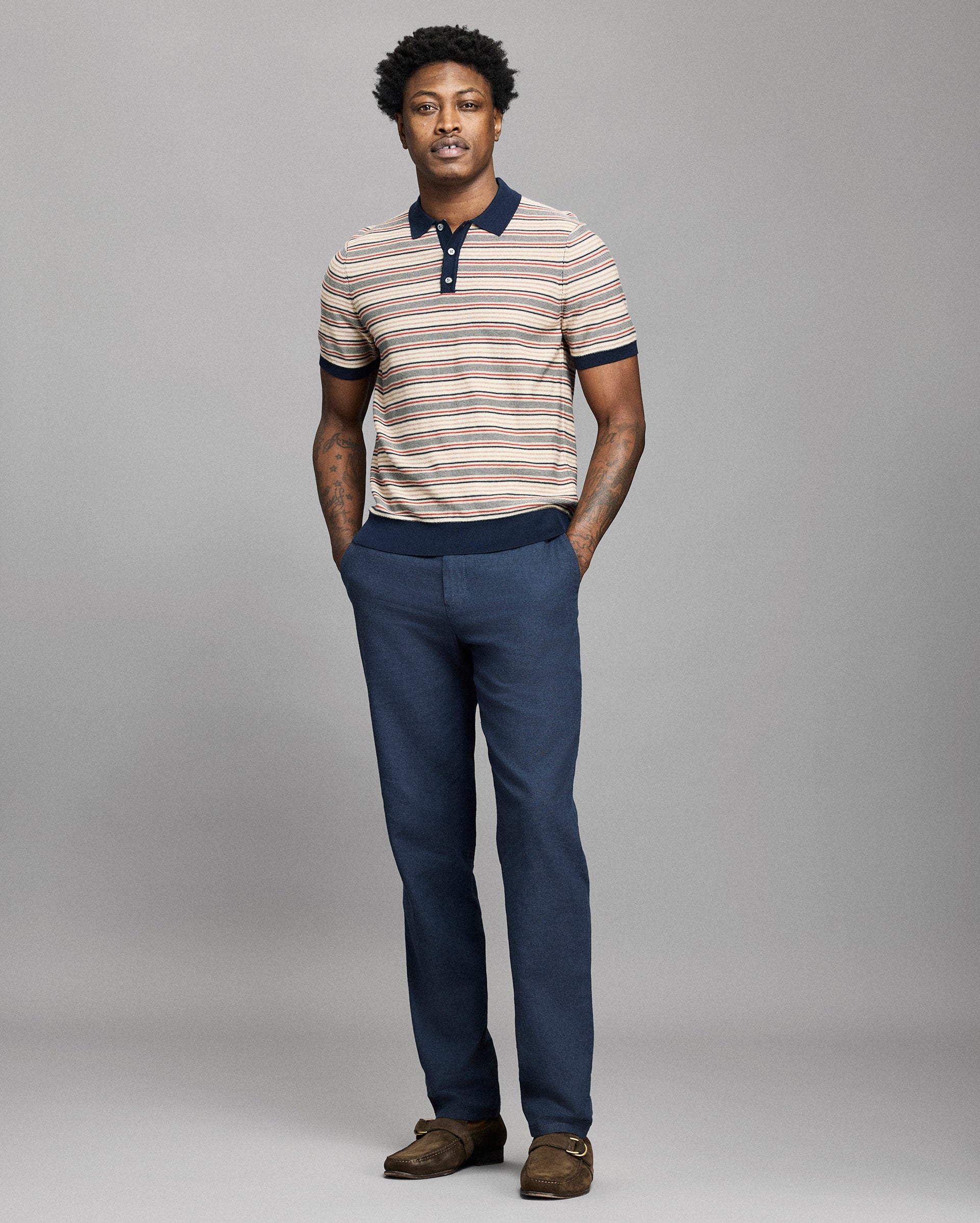 Model wears a striped polo on a light gray background