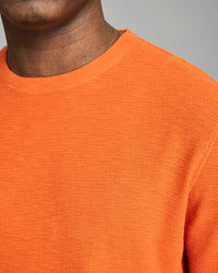 Close-up of an orange sweater worn by a person