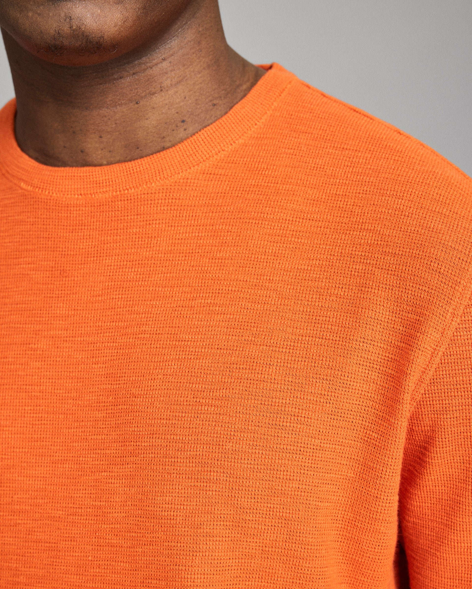 Close-up of an orange sweater worn by a person