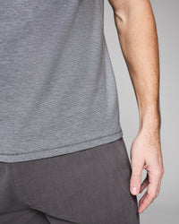 Person wearing a gray sleeveless top and pants against a plain background