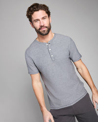 Man wearing a gray henley shirt against a plain background