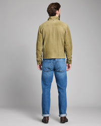 Man wearing a green jacket and blue jeans on a gray background