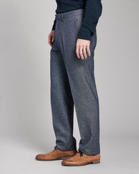 Person wearing blue checkered pants and brown shoes on a gray background