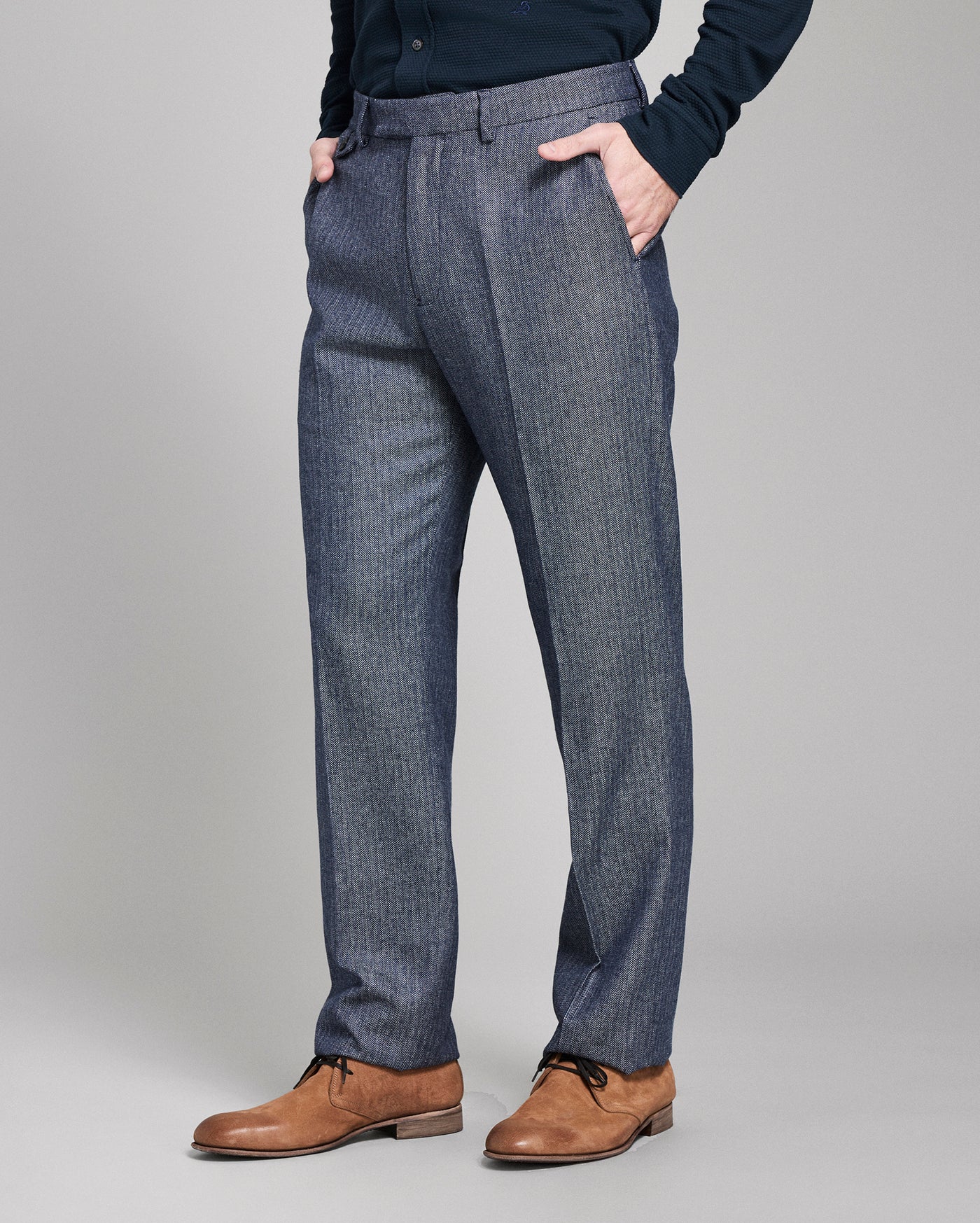 Blue pants worn by a person on a gray background