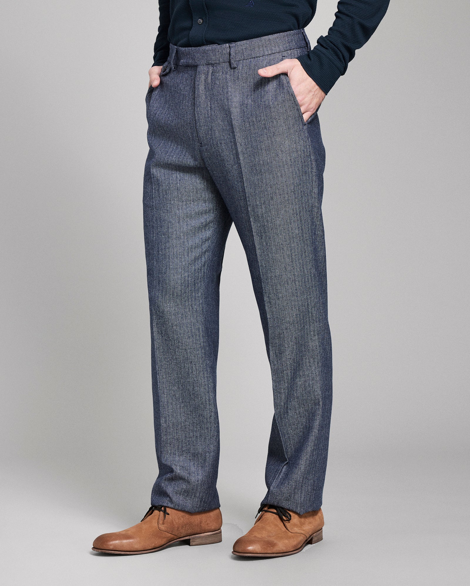 Blue pants worn by a person on a gray background
