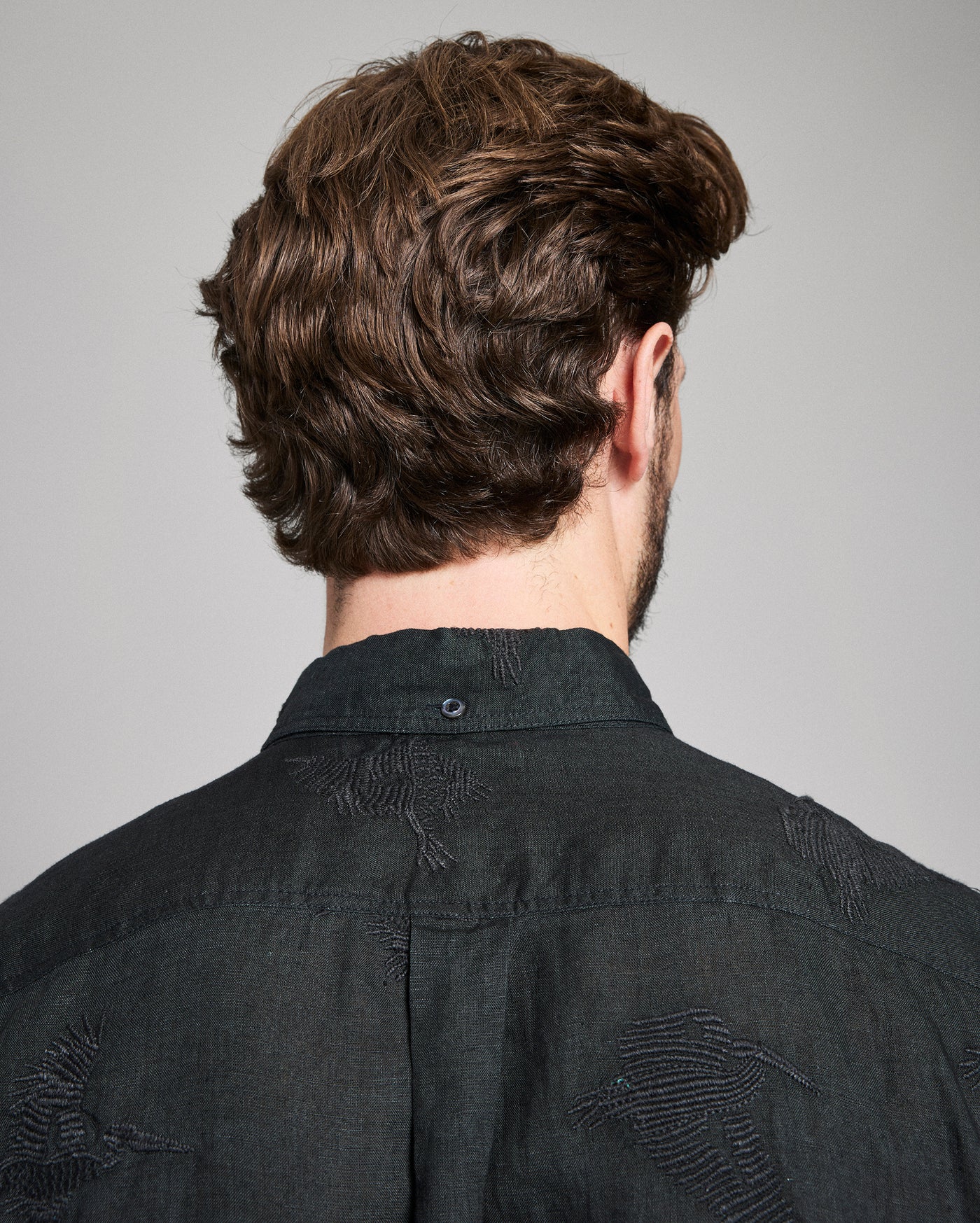 Person wearing a black shirt with a gray background