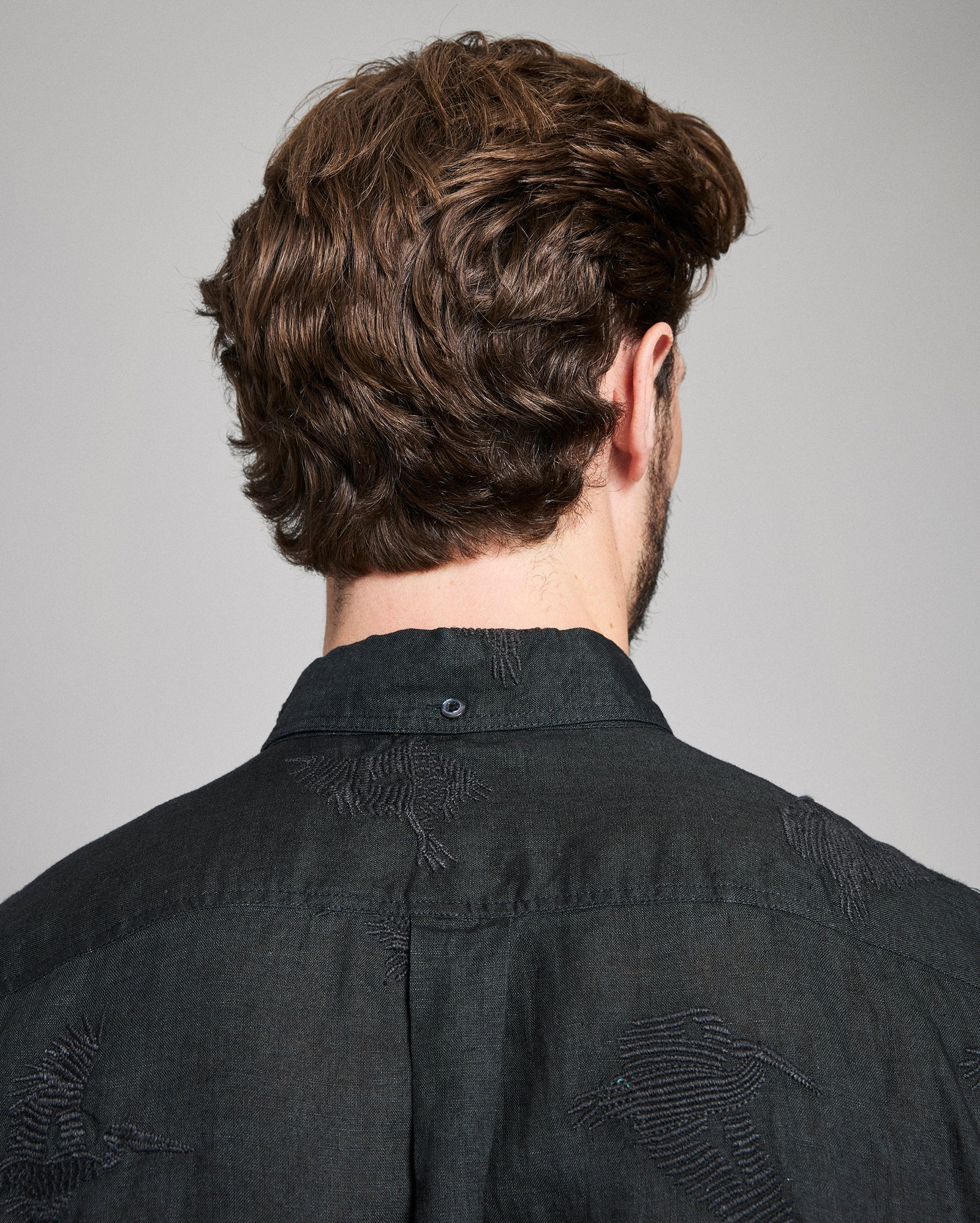 Person wearing a black shirt with a gray background