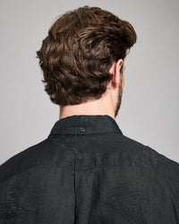 Person wearing a black shirt with a gray background