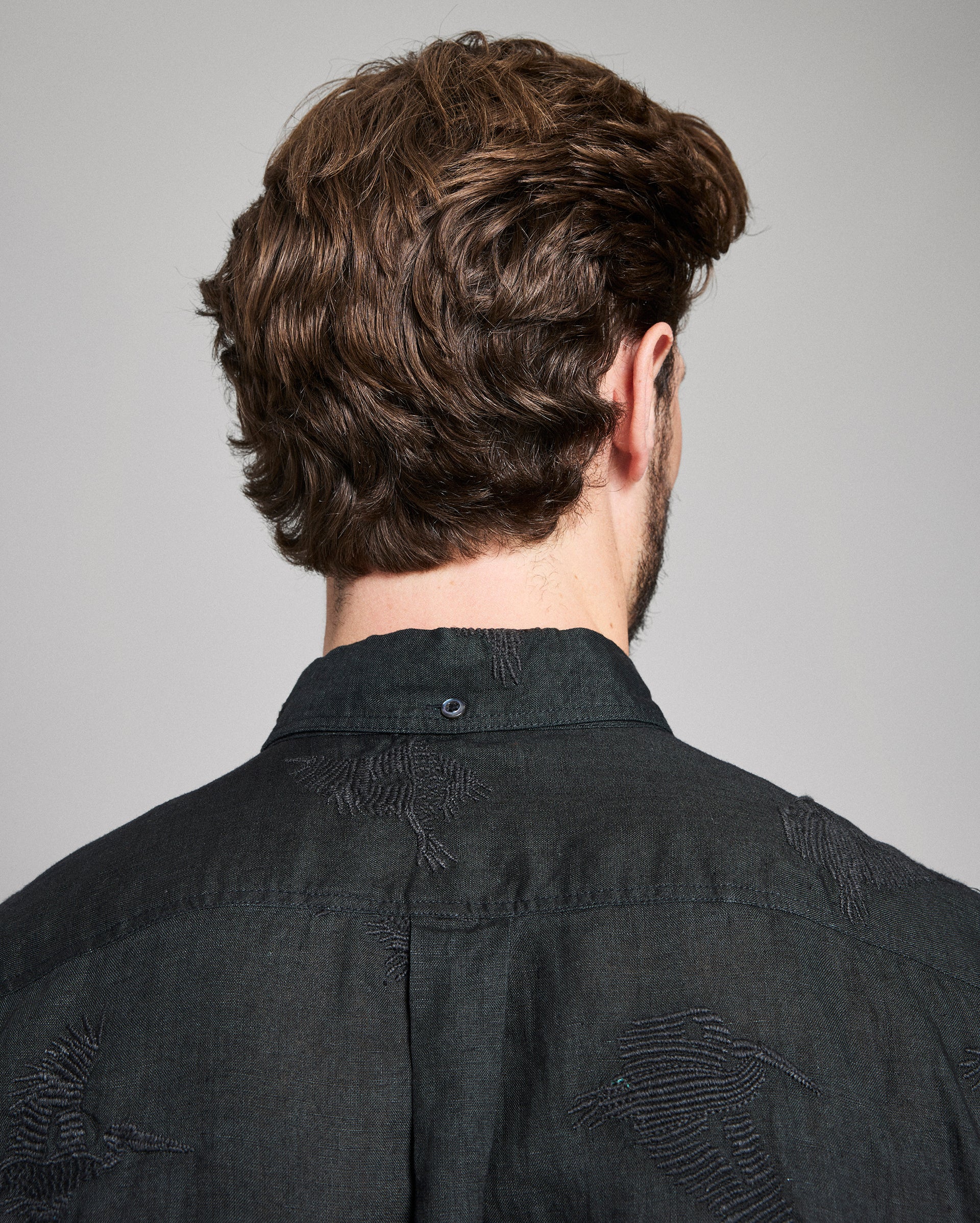 Person wearing a black shirt with a gray background