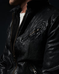 Close-up of a black leather jacket with a dark background