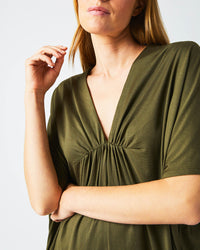 Female model wears the Cocoon Knit Dress in Dark Green
