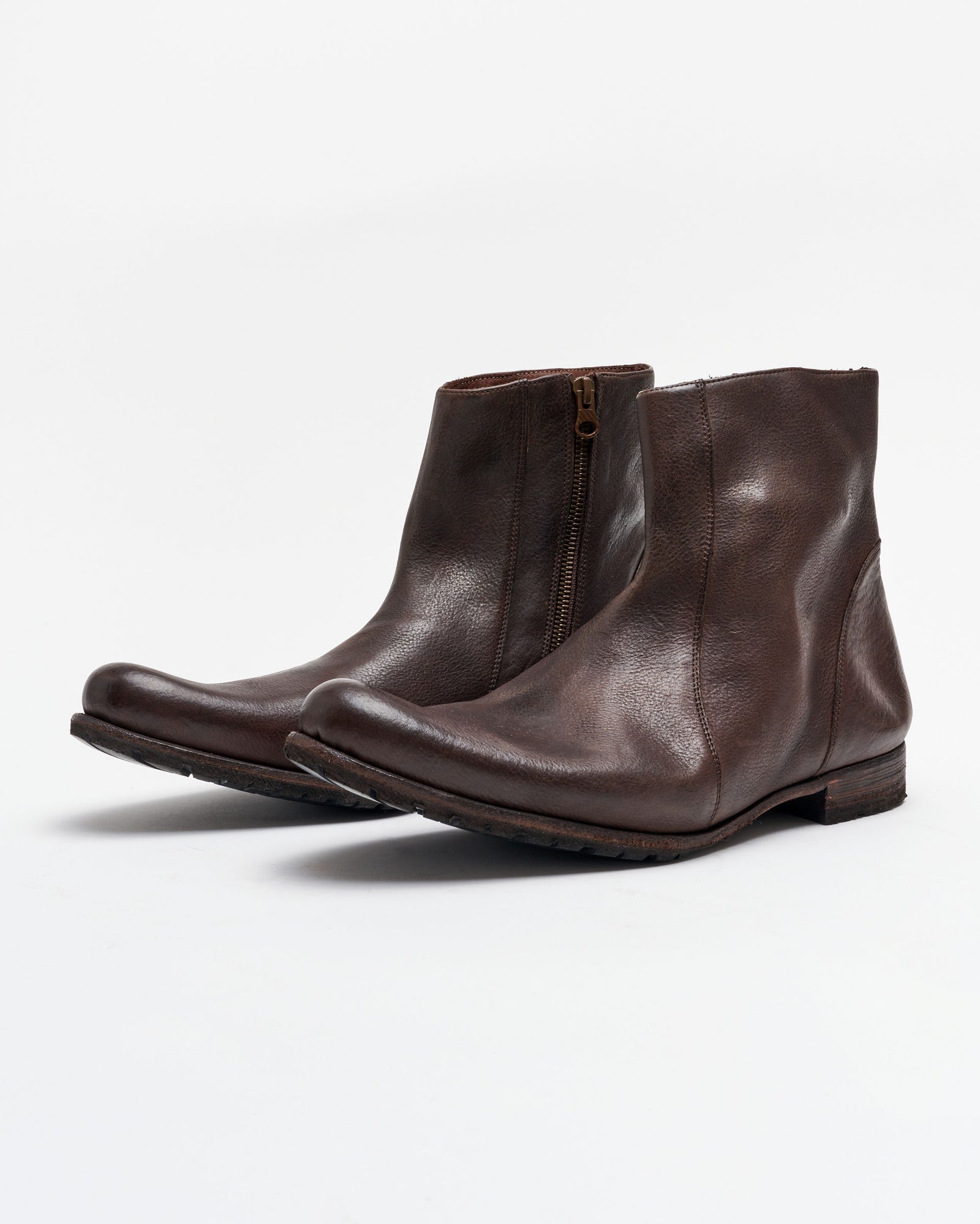 A pair of dark brown leather ankle boots with side zippers and low heels, displayed on a plain white background.