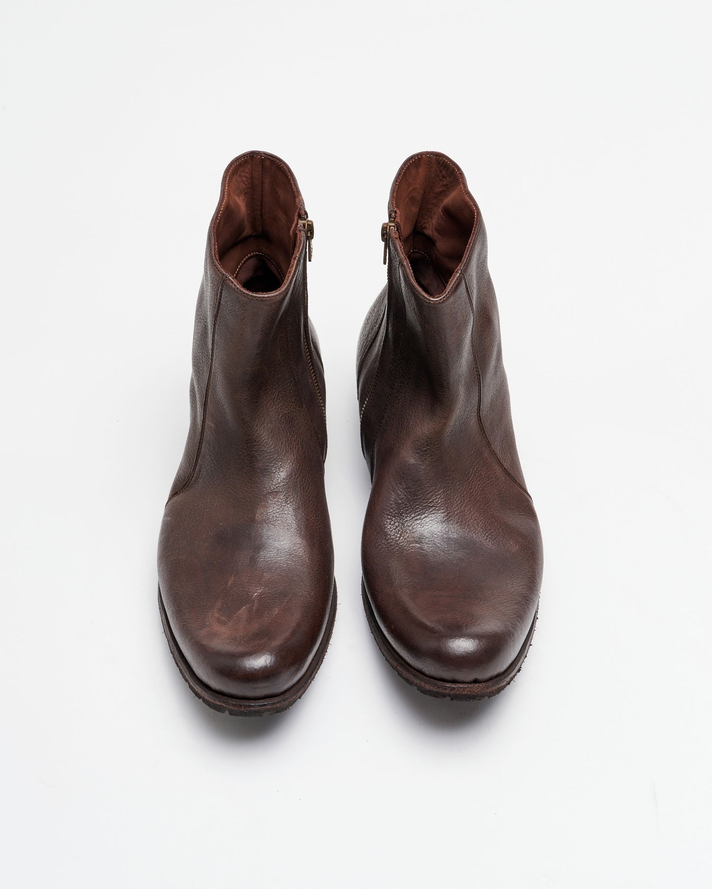 A pair of brown leather ankle boots with zippers on the sides, viewed from above on a plain white background.