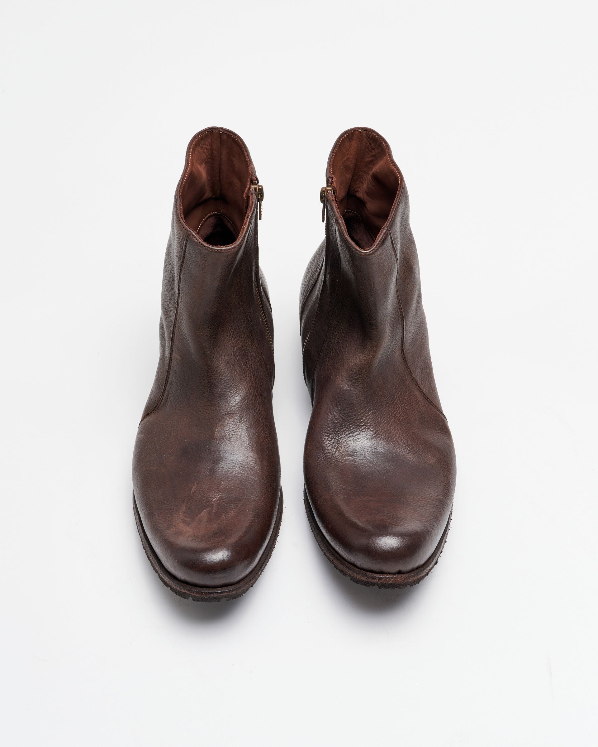 A pair of brown leather ankle boots with zippers on the sides, viewed from above on a plain white background.