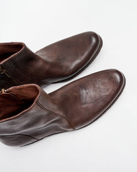 A pair of brown leather ankle boots with side zippers, shown from above on a white background.