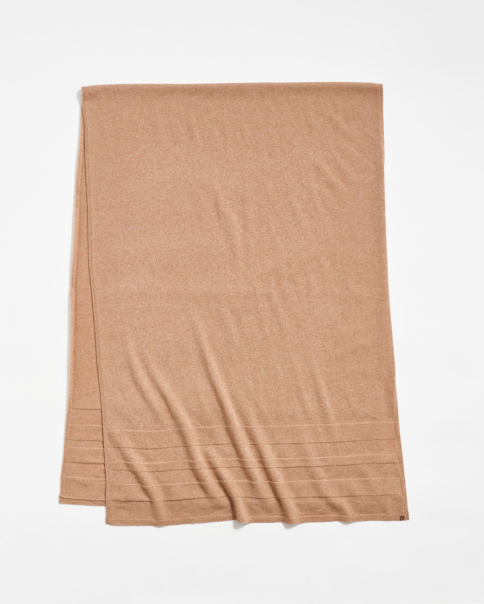 A light brown rectangular scarf is laid flat on a white background, featuring subtle horizontal ribbed lines near one end.