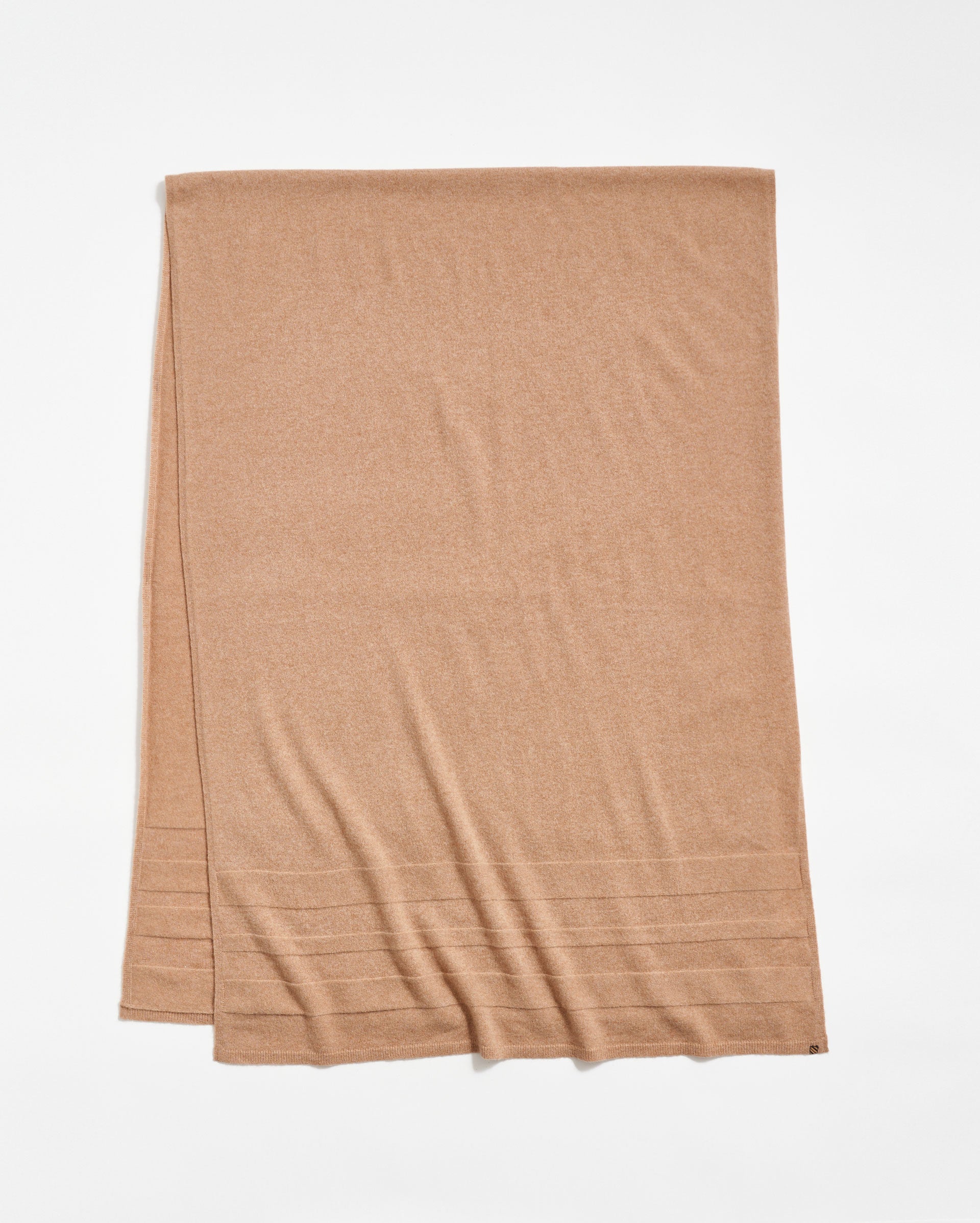 A light brown rectangular scarf is laid flat on a white background, featuring subtle horizontal ribbed lines near one end.